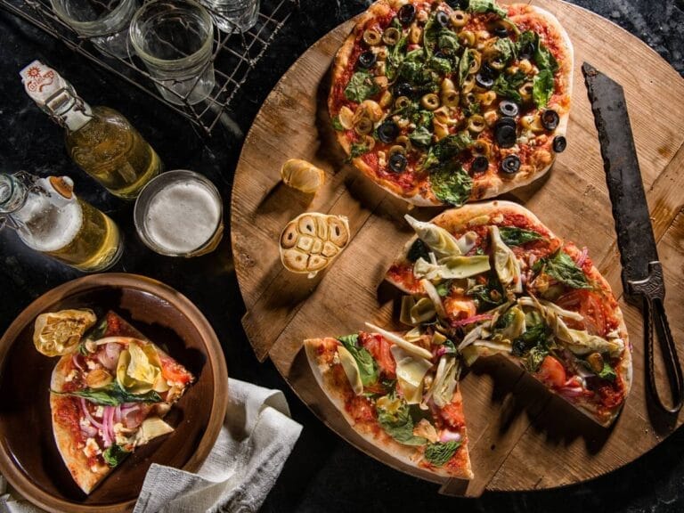 Pizza i składniki na stole. Obrazek w artykule Karczochy pizza - jak przygotować pyszną i zdrową włoską pizzę?