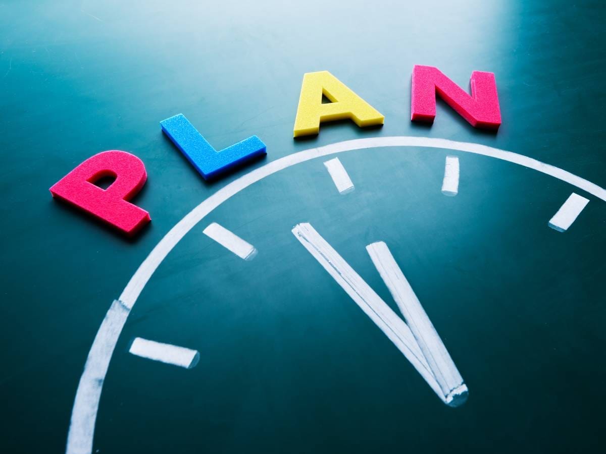 Napis plan i fragment zegara. Obrazek w artykule Jak nie marnować czasu? Najlepsze sposoby na efektywne zarządzanie czasem.