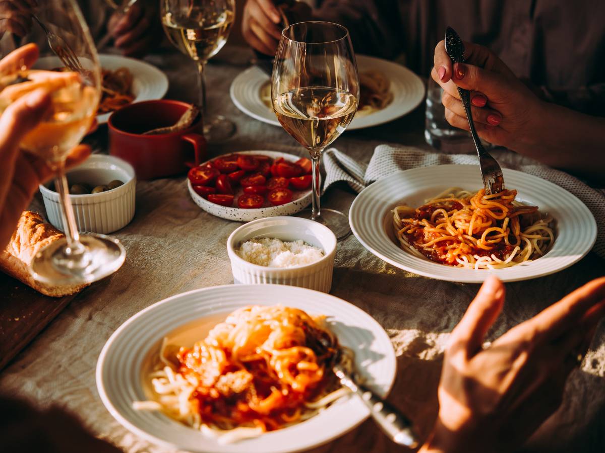 Stół zastawiony talerzami z jedzeniem. Obrazek w tekście Ciepłe danie na przyjęcie imieninowe - najlepsze przepisy i porady.